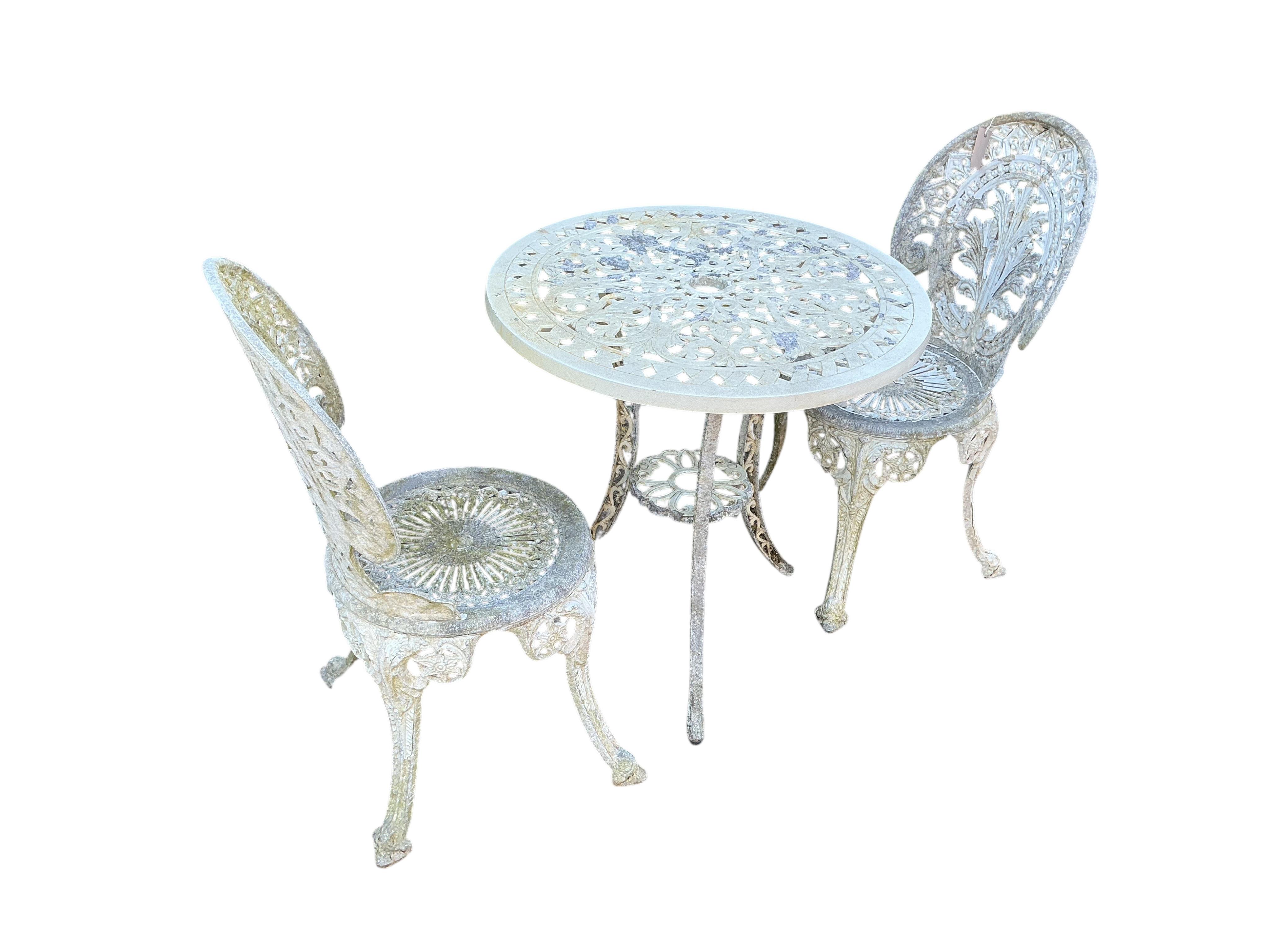 A Victorian style circular painted aluminium garden table, diameter 66cm, height 71cm and two similar garden chairs